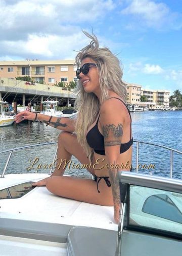 Stefani posing on a boat on her sexy black swim wear