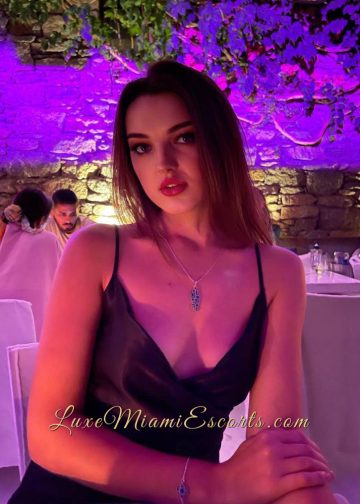 Dasha is sitting at the restaurant in her sexy outfit