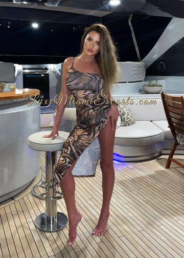Regina posing on a yacht in sexy outfit