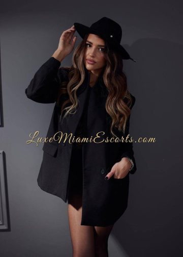 Professional photo of Mila, posing in black blazer and hat
