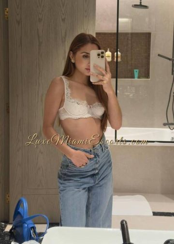 Selfie of Kathy, dressed in blue jeans and white bra