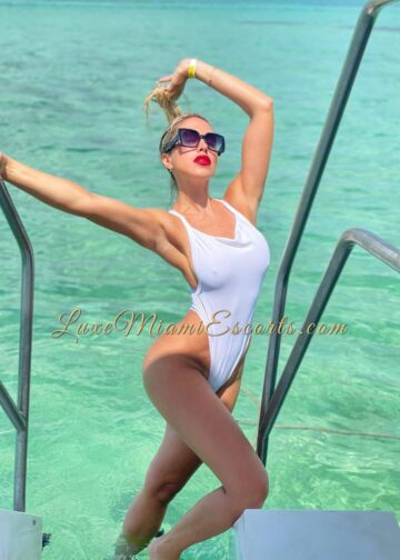Teresa posing by the pool in white swimwear and sunglasses