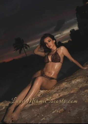 Elena posing outdoors in brown swimwear