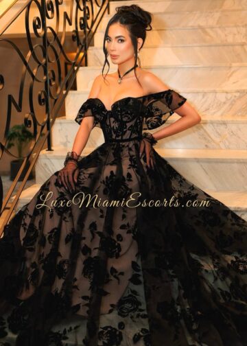 Angelina posing on a stairs, wearing very long black dress