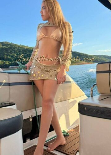 Blonde Miami escort Kiara posing on the yacht in sexy swimwear and short skirt