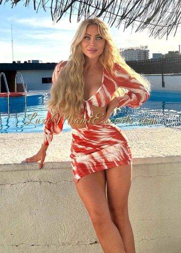 Gorgeous blonde with long hair posing in her very sexy red and white dress