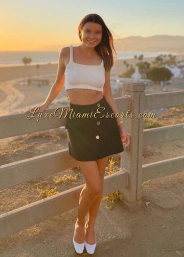 Amateur photo of amazing Miami escort Nika, wearing white top, black skirt and white heels