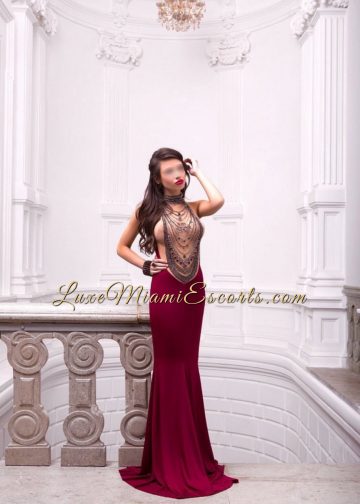 Gorgeous escort model in Miami posing in her long evening dress