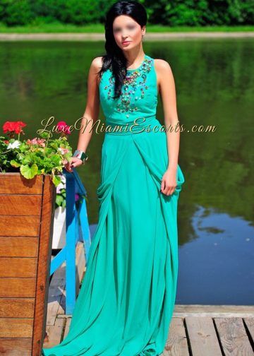 Elegant Miami escort girl Natally posing in her evening dress by the water